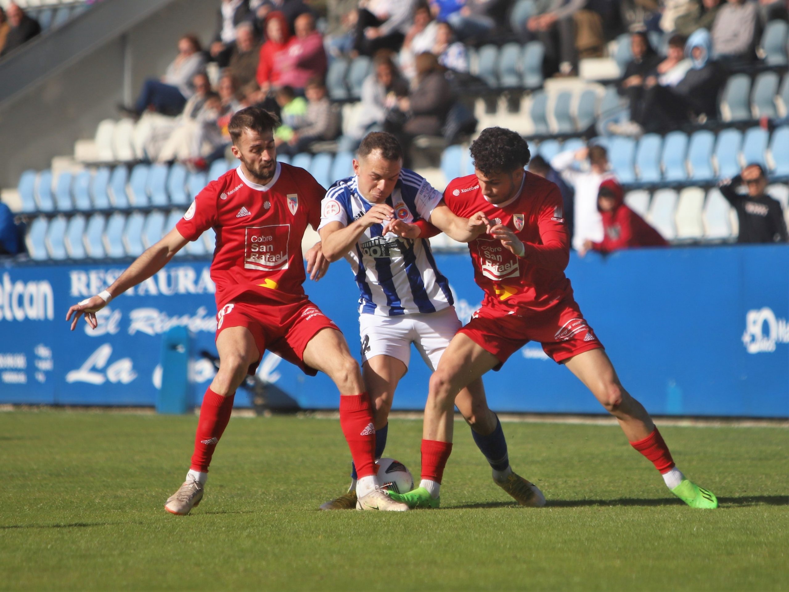 Roque e Parapar loitan por un balón ante un xogador local. Foto: RS Gimnástica.